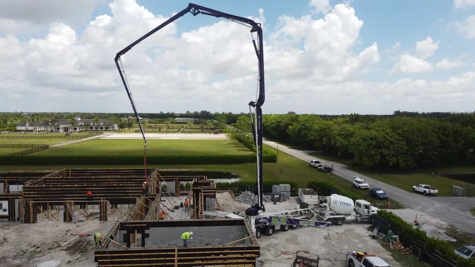 Boom pump pouring foundation walls, aerial view