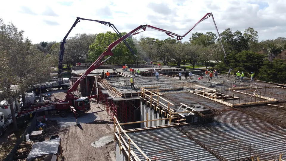 Boom pump reaching over a multi-level building pour, aerial view